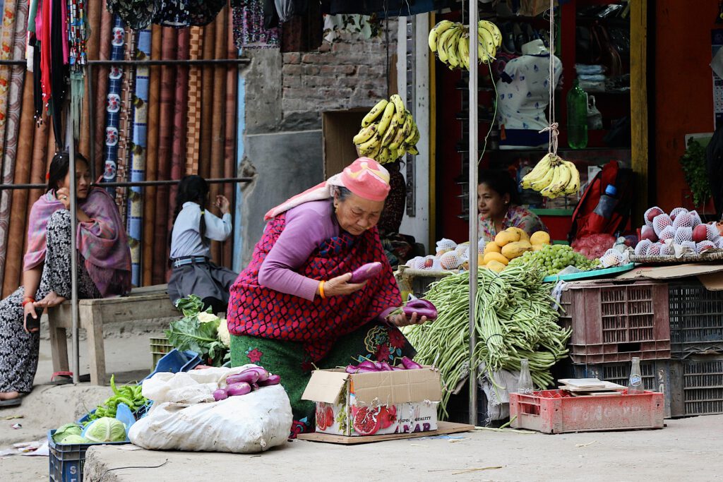 Woman choose vegetables at a Nepalese vegetable stand.
